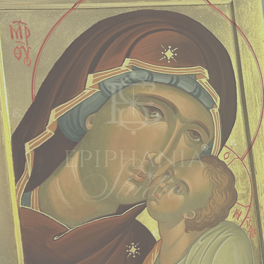 A close-up of a Byzantine-style religious icon painting showing the Virgin Mary holding the infant Jesus, with a gold background and a large semi-transparent 'EPIPHANIA STUDIO' watermark across the center.