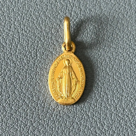 Gold pendant on a blue grey textured background